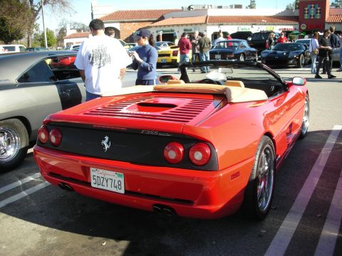 1998 Ford Crown Victoria - red Ferrari F355 Spider with tan top and quad taillights parked rear-first at a crowded car meet.