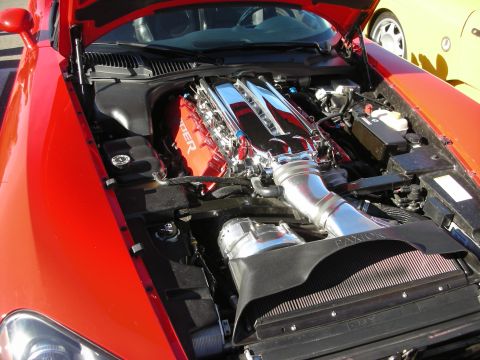 1998 Ford Crown Victoria - open hood of a red Dodge Viper reveals its large V10 engine with red Viper-branded intake and chrome piping.