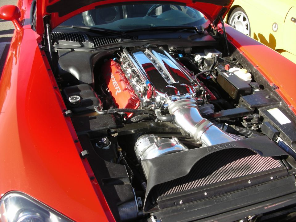 Open engine bay of a red Dodge Viper showing the V10 with Viper valve covers