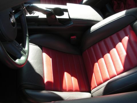 1998 Ford Crown Victoria - Sunlit two-tone interior showing red and black quilted leather seats and a center console in a sports coupe.