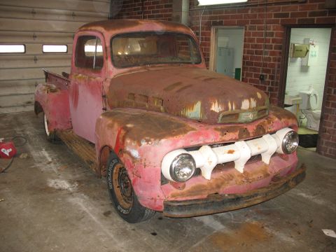 1952 Ford Pickup - This weathered 1952 Ford Pickup shows significant rust but retains its classic body style.