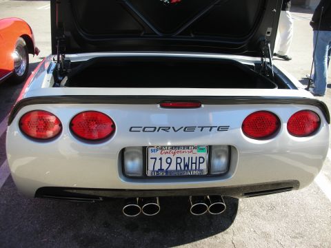 1998 Ford Crown Victoria - Silver Corvette rear with quad round taillights, CORVETTE lettering, dual exhaust, and a California license plate.