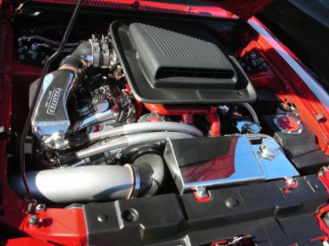 1998 Ford Crown Victoria - engine bay of a red car featuring a black shaker scoop, chrome Vortech supercharger and polished intake piping under the hood.