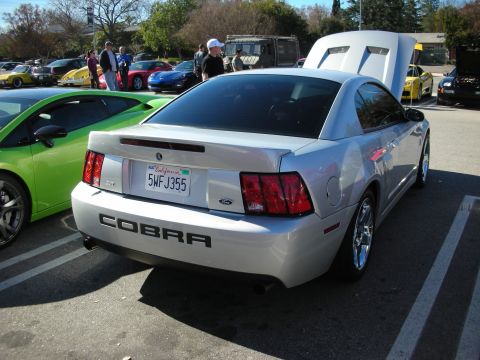 1998 Ford Crown Victoria - silver Mustang Cobra coupe shows its rear COBRA badging and California plate with the trunk open at a car meet.