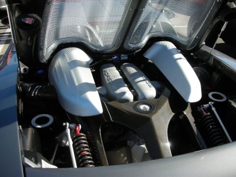 1998 Ford Crown Victoria - mid-engine bay of an exotic supercar showing a V engine with white runners, carbon fiber and visible coilover shocks.