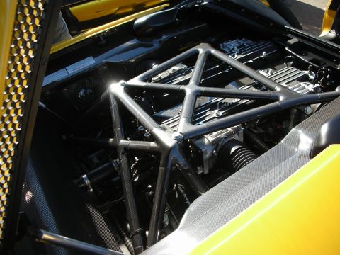 1998 Ford Crown Victoria - mid-engine bay of a yellow Lamborghini showing the V12, tubular space-frame, and coilover suspension.