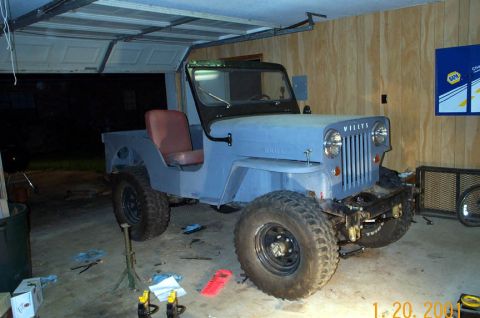 1954 Jeep Wrangler - A light blue Jeep CJ-3A is parked inside a garage, appearing to be undergoing some work.