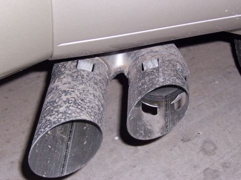 2000 Ford Excursion - Close-up of a vehicle's dual exhaust system, showing the pipes extending from underneath the body.
