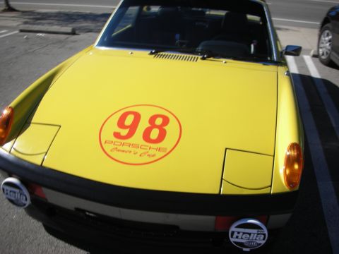 1998 Ford Crown Victoria - yellow front hood of a Porsche 914 displays a red '98 Porsche Owners Club decal flanked by round Hella driving lamps.