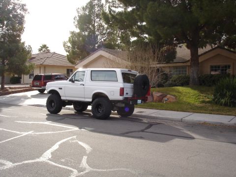 1996 Ford Bronco - White 1996 Ford Bronco with large tires and spare tire mounted on the rear door.