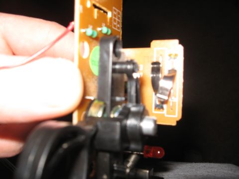 1990 Ford Bronco - Electronic circuit board with a red LED and a wire being held by a finger.