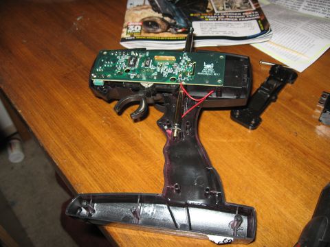 1990 Ford Bronco - The internal components of an RC car remote control are laid out on a wooden surface.