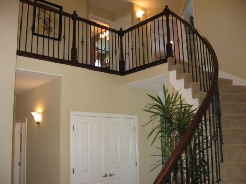 1995 Ford Bronco - A view of a home's interior staircase, a curved dark wood banister and carpeted steps.