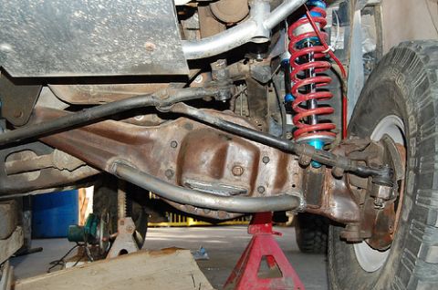 1968 Ford Mustang - The suspension system of a vehicle, likely modified for off-road use, is shown supported by jack stands.