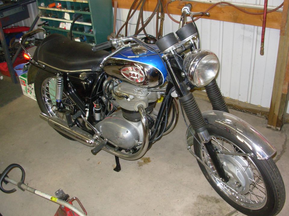 Chrome and blue BSA motorcycle parked in a garage, 3/4 front view