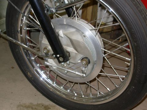 1968 BSA Lightning - Close-up view of a motorcycle's front wheel, the spoked rim and brake mechanism.
