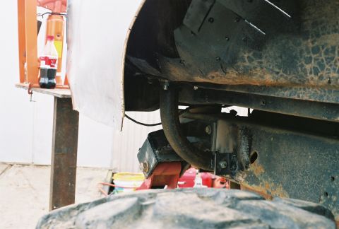 1978 Ford Bronco - Close-up view of vehicle suspension and roll cage components, with a bottle of Coca-Cola in the background.