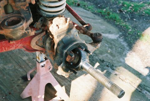 1978 Ford Bronco - Close-up of a vehicle's front axle assembly, showing suspension components and a drive shaft.