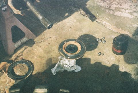 1978 Ford Bronco - Vehicle axle components are laid out on the ground, possibly during a repair or maintenance process.