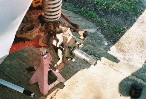 1978 Ford Bronco - Close-up of a front axle assembly, likely for a 4x4 vehicle, supported by jack stands.