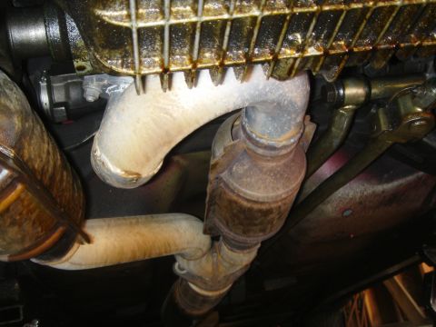 1991 Ford Taurus - Underside view of an exhaust system, including a catalytic converter and oil pan, with visible text from Supermotors.net.
