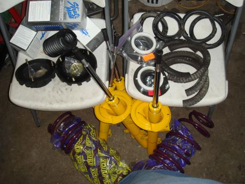 1993 Ford Taurus - Various car suspension components are laid out on chairs and the floor.