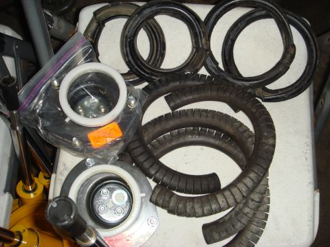 1993 Ford Taurus - A collection of various suspension components, including several coil springs and rubber bumpers, are laid out on a white surface.