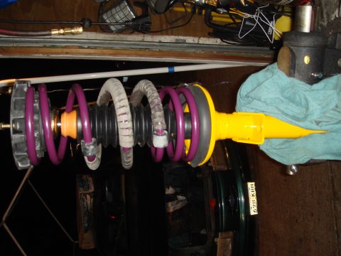 1993 Ford Taurus - A disassembled car suspension component is shown, with purple springs and a yellow shock absorber.