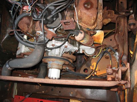 1952 Ford Pickup - Close-up view of a corroded engine compartment with visible hoses and electrical wiring.