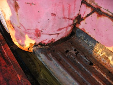 1952 Ford Pickup - The lower body panel and bed of a vehicle show extensive rust and deterioration.