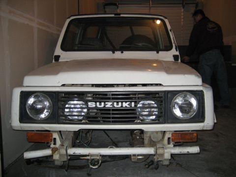 1990 Ford Bronco - Front view of a white Suzuki Samurai, showing the grille and headlights.