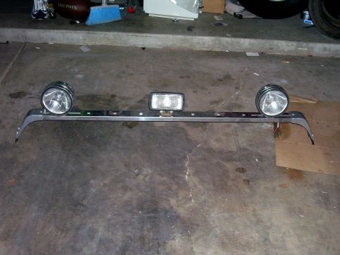 1991 Ford Bronco - Chrome light bar with two round headlights and one rectangular fog light, likely an aftermarket accessory.