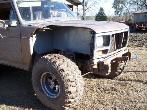 1981 Ford Bronco - This heavily modified Ford Bronco shows significant damage to its front end, including a missing fender and grille.