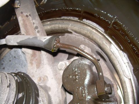 1997 Ford F-150 - This image shows a close-up view of a vehicle's brake caliper and fluid line, covered in grease and grime.