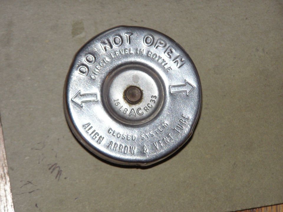 Chrome AC RC33 15 lb closed-system radiator cap stamped DO NOT OPEN, on gray background