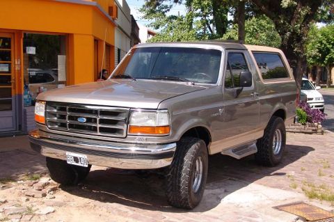 1986 Ford Bronco - This Ford Bronco SUV features a tan two-tone paint scheme and a removable tan top.