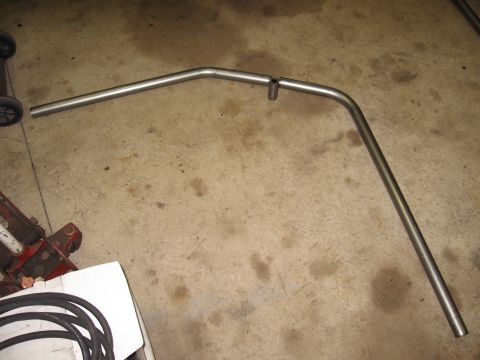1977 Ford F-150 - A bent metal exhaust pipe is shown on a concrete floor.