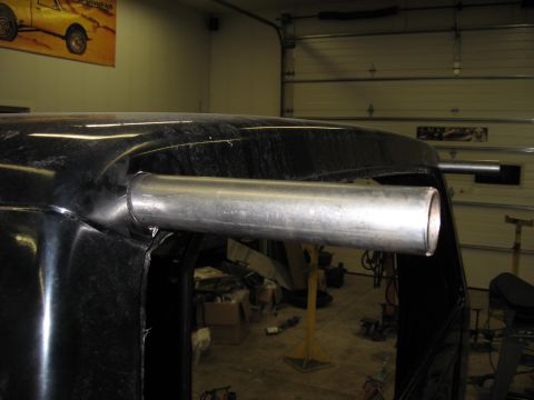 1977 Ford F-150 - Custom exhaust pipes are installed on the roof of a black truck cab in a workshop.