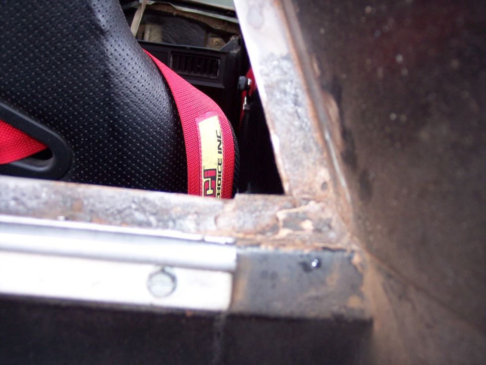 Racing seat with red harness labeled "P2 CHOICE INC"