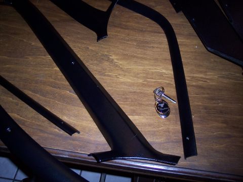 1972 Ford Ranchero - Black interior trim pieces and a keychain are laid out on a wooden surface.