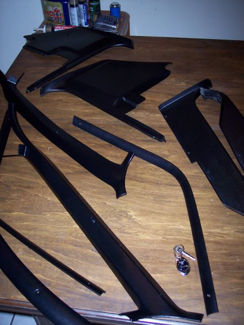 1972 Ford Ranchero - Various black interior trim pieces are displayed on a wooden table, alongside a set of keys.