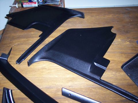 1972 Ford Ranchero - Black interior trim pieces are displayed on a wooden table, possibly for restoration.