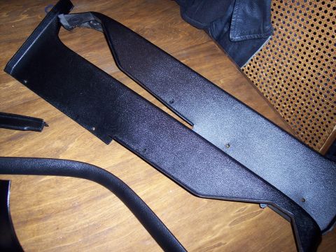 1972 Ford Ranchero - Several black plastic interior trim pieces are displayed on a wooden table, with a leather jacket and chair in the background.