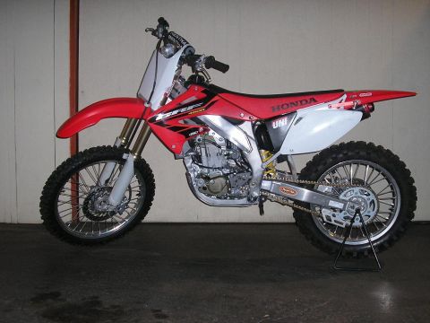 1900 Honda Big Red - This Honda dirt bike is red with white accents and knobby tires.