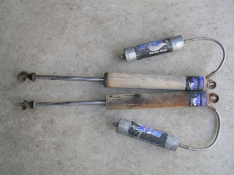 1985 Ford Bronco II - Two pairs of Fox Racing Shox shock absorbers are laid out on a concrete surface.