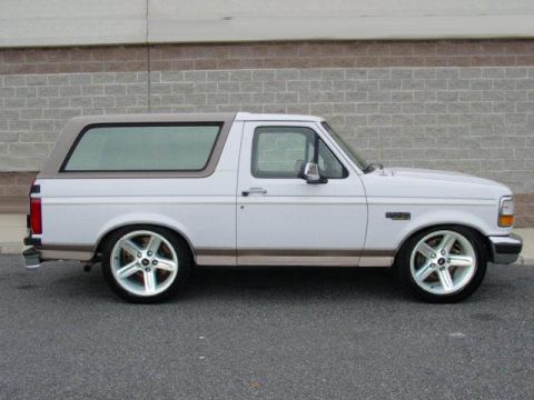 1989 Ford Bronco - 1989 Ford Bronco shown in side profile against a brick wall.