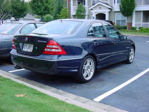 1984 BMW 3 Series - A dark blue Mercedes-Benz sedan is parked in a lot next to another vehicle.