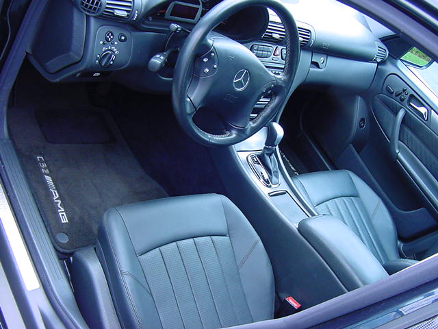 Interior of a Mercedes-Benz C32 AMG showing the dashboard, steering wheel, gear shifter, and front seats