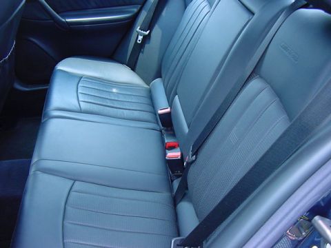 1984 BMW 3 Series - Interior view of the rear seats and seatbelts, showing the blue upholstery and door panel.