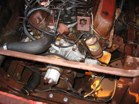 1952 Ford Pickup - A close-up view of a vehicle's engine bay reveals a complex arrangement of rusty parts and electrical wiring.